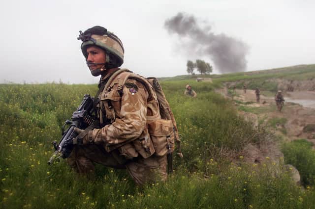 A Royal Marine watches for Taliban movements after an airstrike was called in on a Taliban position in March 2007 near Kajaki in the Afghan province of Helmand (Picture: John Moore/Getty Images)