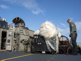 US sailors with material recovered off the coast of South Carolina following the shooting down of a Chinese high-altitude balloon (Picture: Ryan Seelbach/US Navy via AP)