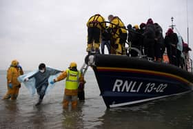 People are helped ashore from an RNLI lifeboat on a beach at Dungeness, south-east England, after being rescued while crossing the English Channel (Picture: Ben Stansall/AFP via Getty Images)