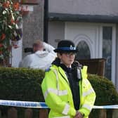 Police and forensic investigators outside the house in St Helens