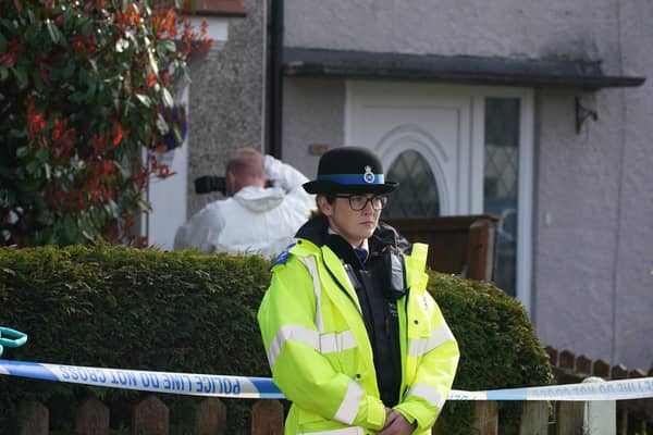 Police and forensic investigators outside the house in St Helens