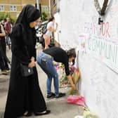 Well-wishers leave flowers and write messages on a wall of condolence following the blaze at Grenfell Tower in 2017.