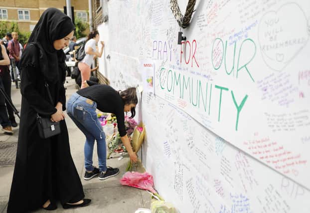 Well-wishers leave flowers and write messages on a wall of condolence following the blaze at Grenfell Tower in 2017.