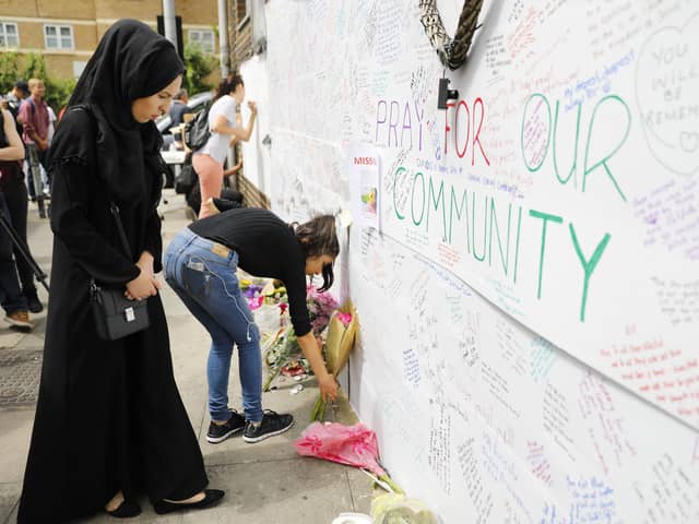 Well-wishers leave flowers and write messages on a wall of condolence following the blaze at Grenfell Tower in 2017.