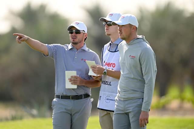 Ewen Ferguson and Richard Mansell talk tactics on the 18th hole at Abu Dhabi Golf Club. Picture: Ross Kinnaird/Getty Images.