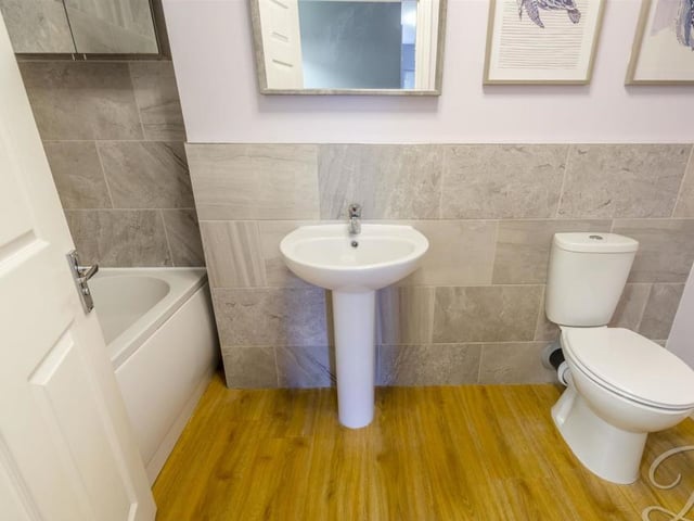 The main bathroom at the £250,000-plus property comprises a fitted bath with overhead shower, low-flush WC and pedestal wash basin.