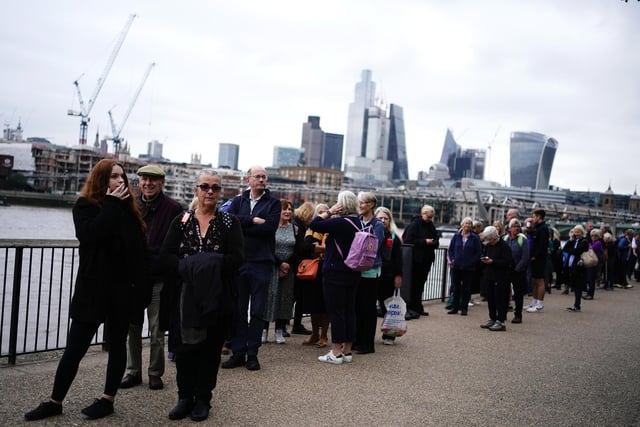 Members of the public in the queue on the South Bank near to Millennium Bridge, London, as they wait to view Queen Elizabeth II lying in state ahead of her funeral on Monday. The queue itself is moving at around 0.5 miles per hour.