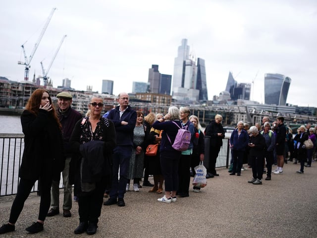 Members of the public in the queue on the South Bank near to Millennium Bridge, London, as they wait to view Queen Elizabeth II lying in state ahead of her funeral on Monday. The queue itself is moving at around 0.5 miles per hour.