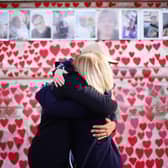 People hugging at the National Covid Memorial Wall in London