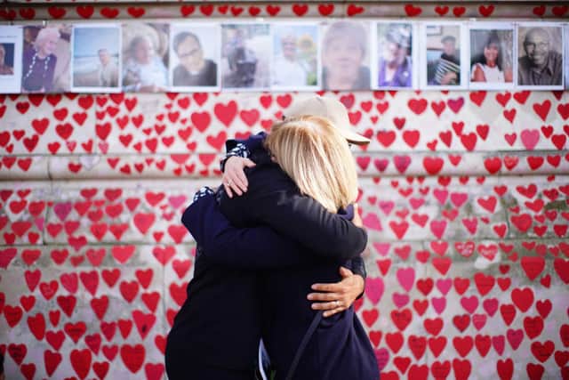 People hugging at the National Covid Memorial Wall in London