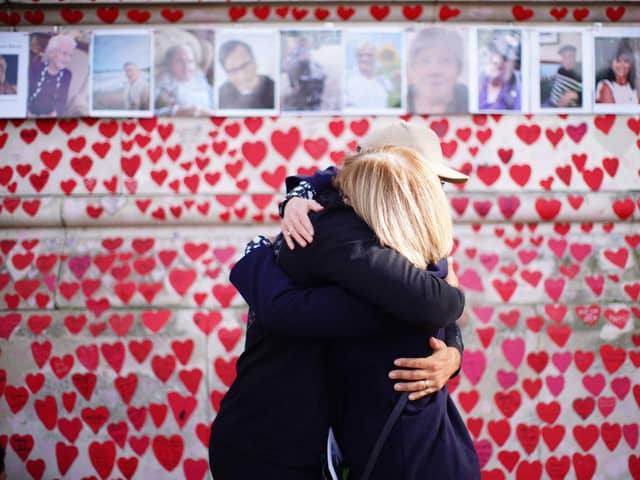 People hugging at the National Covid Memorial Wall in London