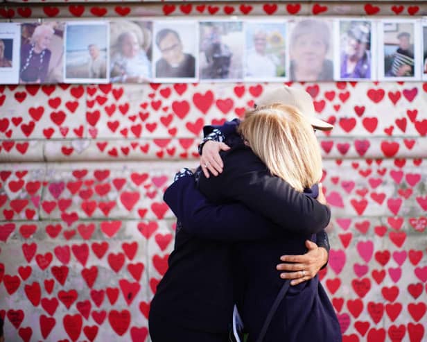 People hugging at the National Covid Memorial Wall in London