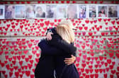 People hugging at the National Covid Memorial Wall in London