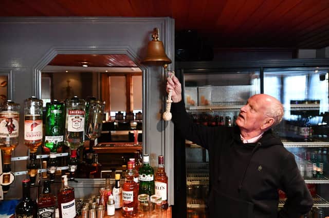 Andy Hutton of Lynch's Pub in Glasgow rings the last orders bell