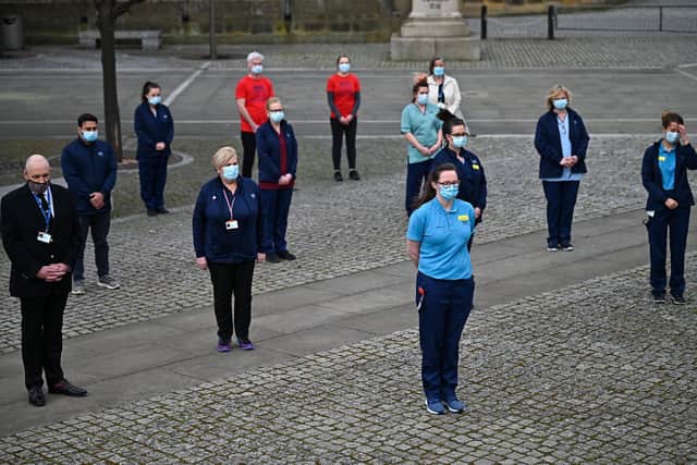 Staff from the Glasgow Royal Infirmary gather outside the hospital for a minute's silence for all those who have died in the Covid pandemic (Picture: Jeff J Mitchell/Getty Images)