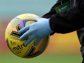 The matchball is disinfected during a Scottish Premiership match
(Ross MacDonald / SNS Group)