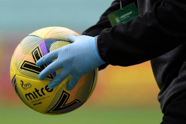 The matchball is disinfected during a Scottish Premiership match
(Ross MacDonald / SNS Group)