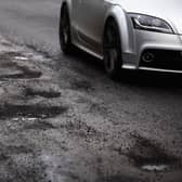 A road user tries to avoid potholes in Glasgow