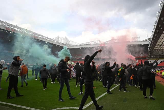 Supporters protest against Manchester United's owners on the Old Trafford pitch, forcing the match against Liverpool to be postponed (Photo by OLI SCARFF/AFP via Getty Images)