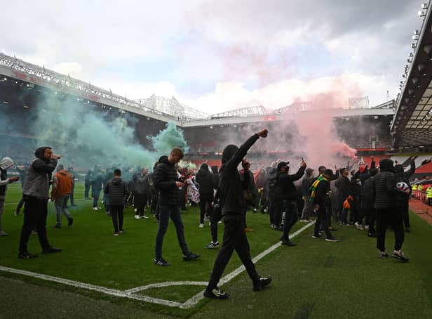 Supporters protest against Manchester United's owners on the Old Trafford pitch, forcing the match against Liverpool to be postponed (Photo by OLI SCARFF/AFP via Getty Images)
