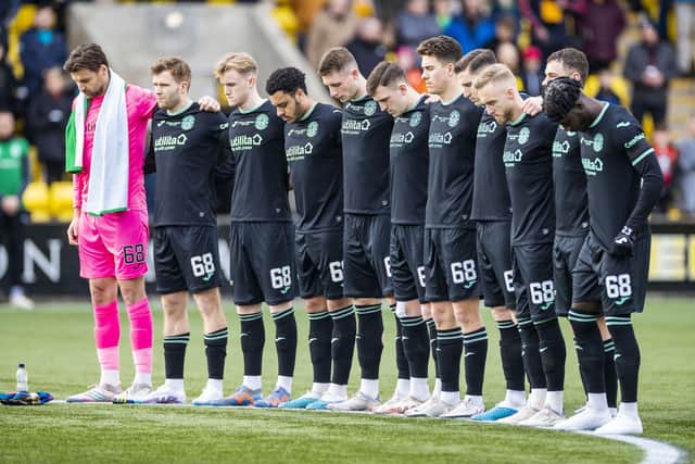 The Hibs players stand for a minute's silence for their former chairman Ron Gordon, who died last month.