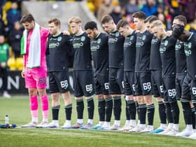 The Hibs players stand for a minute's silence for their former chairman Ron Gordon, who died last month.