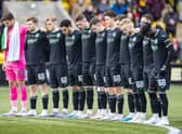 The Hibs players stand for a minute's silence for their former chairman Ron Gordon, who died last month.