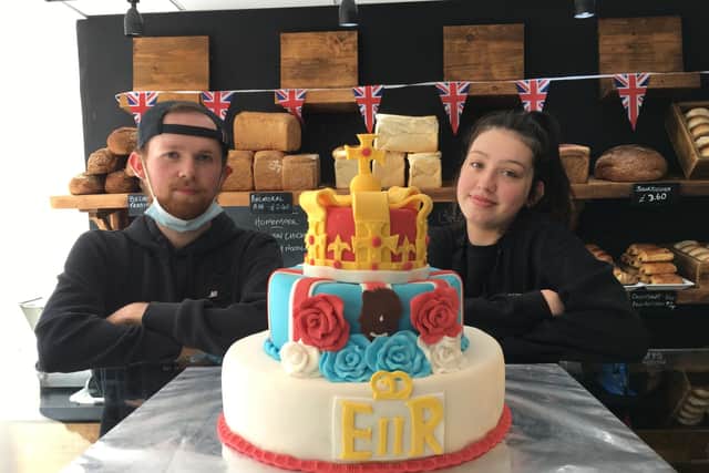 Jude Swan and Stef Ogston, of Byron Baker,y with a Jubilee cake which will be raffled off for charity next weekend. PIC: Contributed.