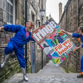 Cris Peploe and Martha Haskins pose with a large-scale version of the Edinburgh Festival Fringe 2023 programme cover in Anchor Close in the city's Old Town. Picture: Jane Barlow/PA Wire