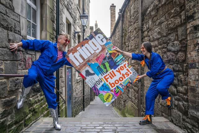 Cris Peploe and Martha Haskins pose with a large-scale version of the Edinburgh Festival Fringe 2023 programme cover in Anchor Close in the city's Old Town. Picture: Jane Barlow/PA Wire