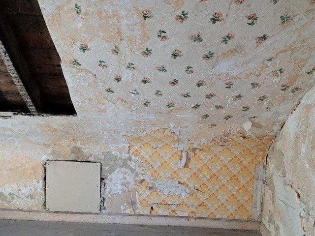 The flat has some original fittings including a porcelain sink and scraps of floral wallpaper.
