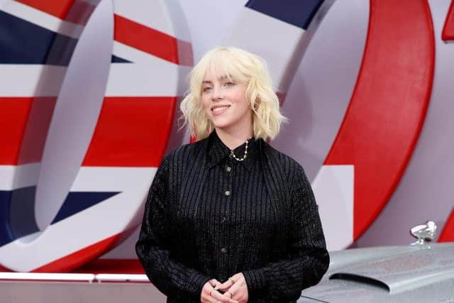 Billie Eilish stands next to James Bonds Aston Martin car at the No Time To Die World Premiere last month. Photo credit: Tim P. Whitby.