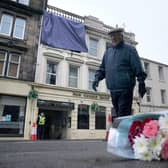 Flowers left at the scene following a fire at the New County Hotel in Perth in which three people died.