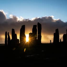 The sun rises behind the Calanais Standing Stones on the Isle Of Lewis. PIC:  ANDY BUCHANAN/AFP via Getty Images)