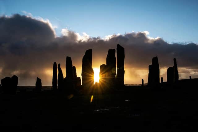 The sun rises behind the Calanais Standing Stones on the Isle Of Lewis.