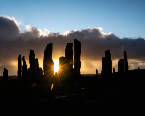 The sun rises behind the Calanais Standing Stones on the Isle Of Lewis. PIC:  ANDY BUCHANAN/AFP via Getty Images)