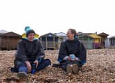 Two friends, wearing coats, have a conversation
