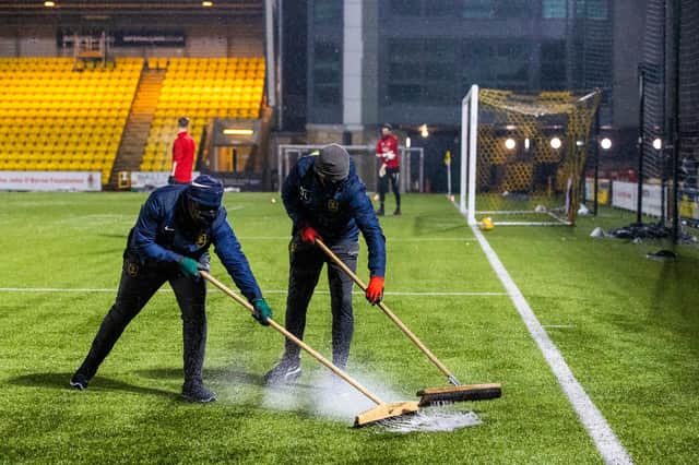 Ground staff sweep rain off the pitch before the postponed Scottish Premiership match between Livingston and Aberdeen at the Tony Macaroni Arena (Photo by Alan Harvey / SNS Group)