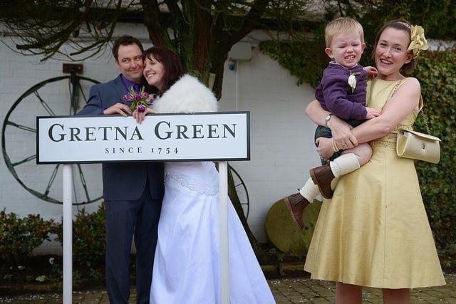 Thomas Foster cries as Jamie Blood and Bridget Foster pose on their wedding day at the Gretna Green Famous Blacksmiths Shop on Valentine's Day 2013.