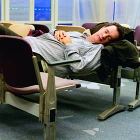 Tom Hanks makes himself comfortable during his stay in an airport in New York in The Terminal