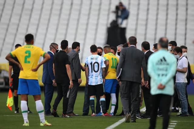 SAO PAULO, BRAZIL - SEPTEMBER 05: Lionel Messi of Argentina and Neymar Jr. of Brazil talk to health authorities as the match is delayed during a match between Brazil and Argentina as part of South American Qualifiers for Qatar 2022 at Arena Corinthians on September 05, 2021 in Sao Paulo, Brazil. (Photo by Alexandre Schneider/Getty Images)