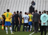SAO PAULO, BRAZIL - SEPTEMBER 05: Lionel Messi of Argentina and Neymar Jr. of Brazil talk to health authorities as the match is delayed during a match between Brazil and Argentina as part of South American Qualifiers for Qatar 2022 at Arena Corinthians on September 05, 2021 in Sao Paulo, Brazil. (Photo by Alexandre Schneider/Getty Images)