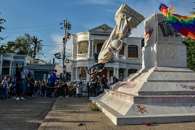Not such a hero? A statue of Christopher Columbus is toppled during a demonstration against the government in Barranquilla, Colombia (Picture: Mery Grandos Herrera/AFP via Getty Images)