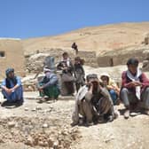 Afghan internally displaced people, who fled to Yakawlang district of Bamyan province due to fighting between Taliban forces and a breakaway group led by one of their former commanders , gather outdoors in Duzdanchisma village.