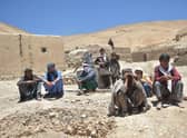 Afghan internally displaced people, who fled to Yakawlang district of Bamyan province due to fighting between Taliban forces and a breakaway group led by one of their former commanders , gather outdoors in Duzdanchisma village.