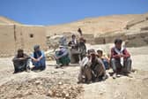 Afghan internally displaced people, who fled to Yakawlang district of Bamyan province due to fighting between Taliban forces and a breakaway group led by one of their former commanders , gather outdoors in Duzdanchisma village.