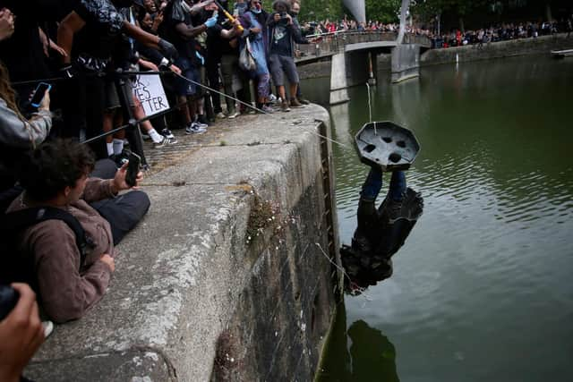 The statue of Edward Colston, a 17th century slave trader meets a watery end in Bristol harbour. Picture: Tom Wren/SWNS