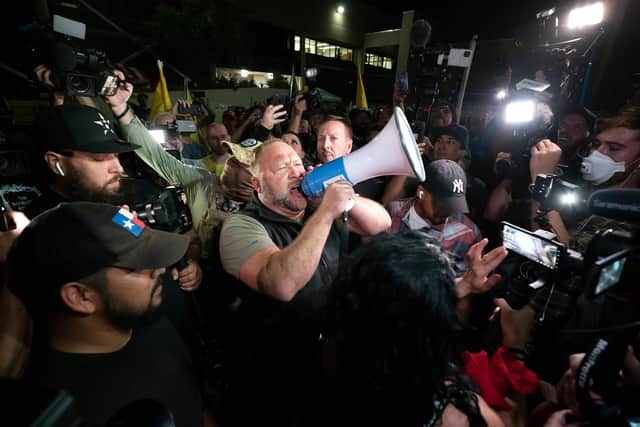 US conspiracy theorist Alex Jones shouts "America is Awake" to a crowd of Trump supporters gathered outside a building where votes are being counted in Phoenix, Arizona (Picture: Olivier Touron/AFP via Getty Images)