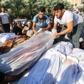 People mourn as they collect the bodies of Palestinians killed in Israeli air raids on October 26, 2023 in Khan Yunis, Gaza. Heading into a third week of heavy bombing from Israel, Gaza buckles under a shortage of basic needs including fuel, whilst several neighbourhoods on the Gaza strip have been wiped out and thousands have died and hundreds of thousands have been displaced.