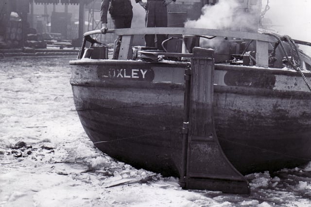 Hull bargee James Walker and engineer Brian Appleyard looking over the stern of their barge, Loxley, which was ice bound at Canal Wharf, Sheffield on January 22, 1963 - the big freeze that hit the country lasted for three months